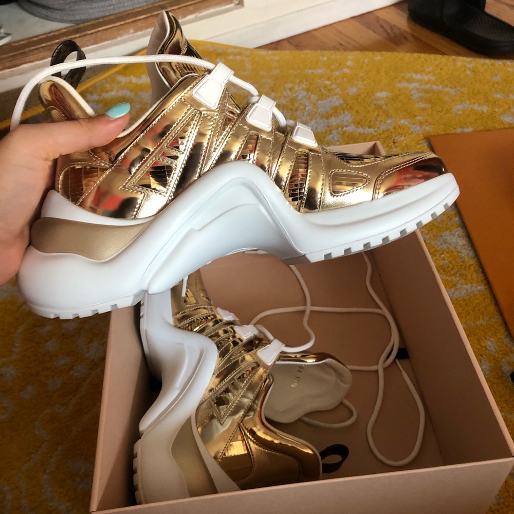 Metallic Gold Louis Vuitton arch light sneakers.